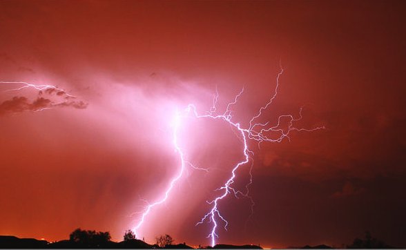 Lightning illuminates the night sky red