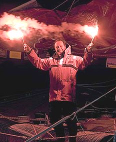 Francis Joyon flares in hand at the finish line